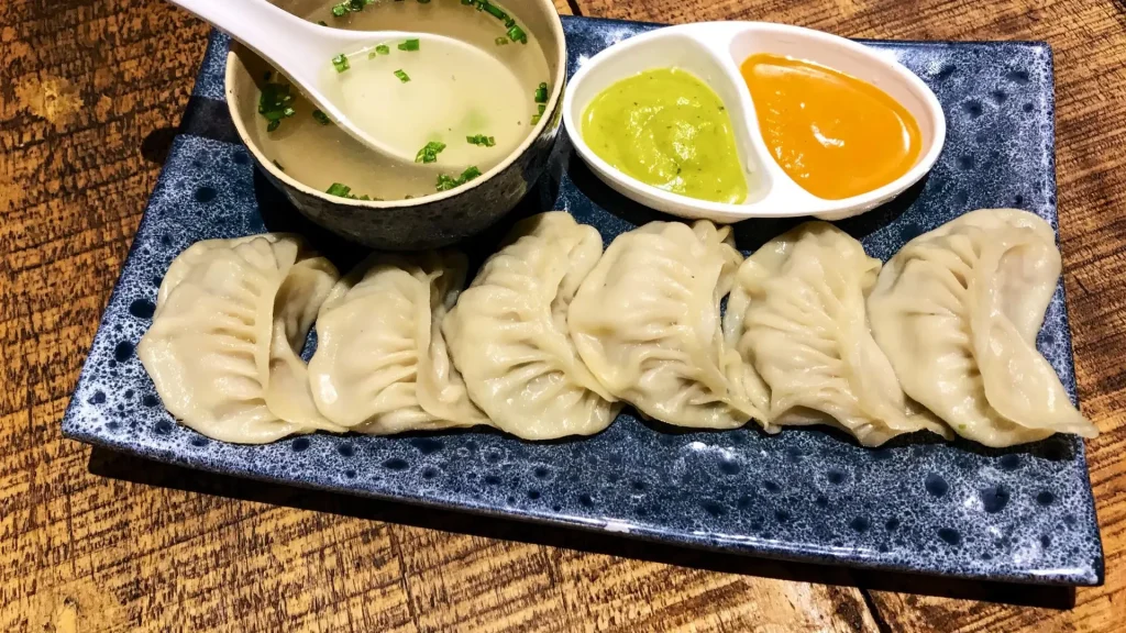 Freshly steamed Nepali momos served with spicy red chutney and green sauce