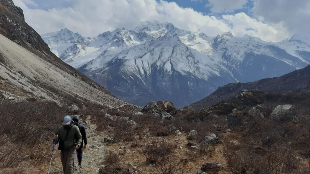 Scenic view of a trekker walking along the Langtang Valley trail toward Himalayan peaks in Nepal